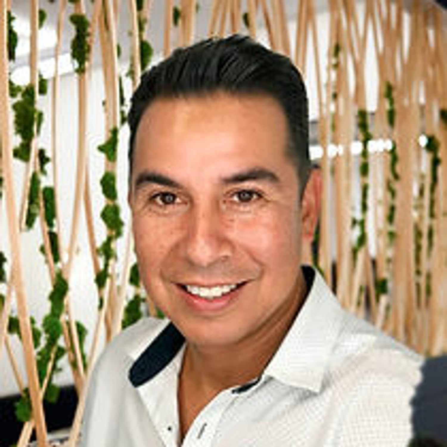 Portrait of Raul, a professional stylist at Tangles Salon, showcasing their expertise and style.